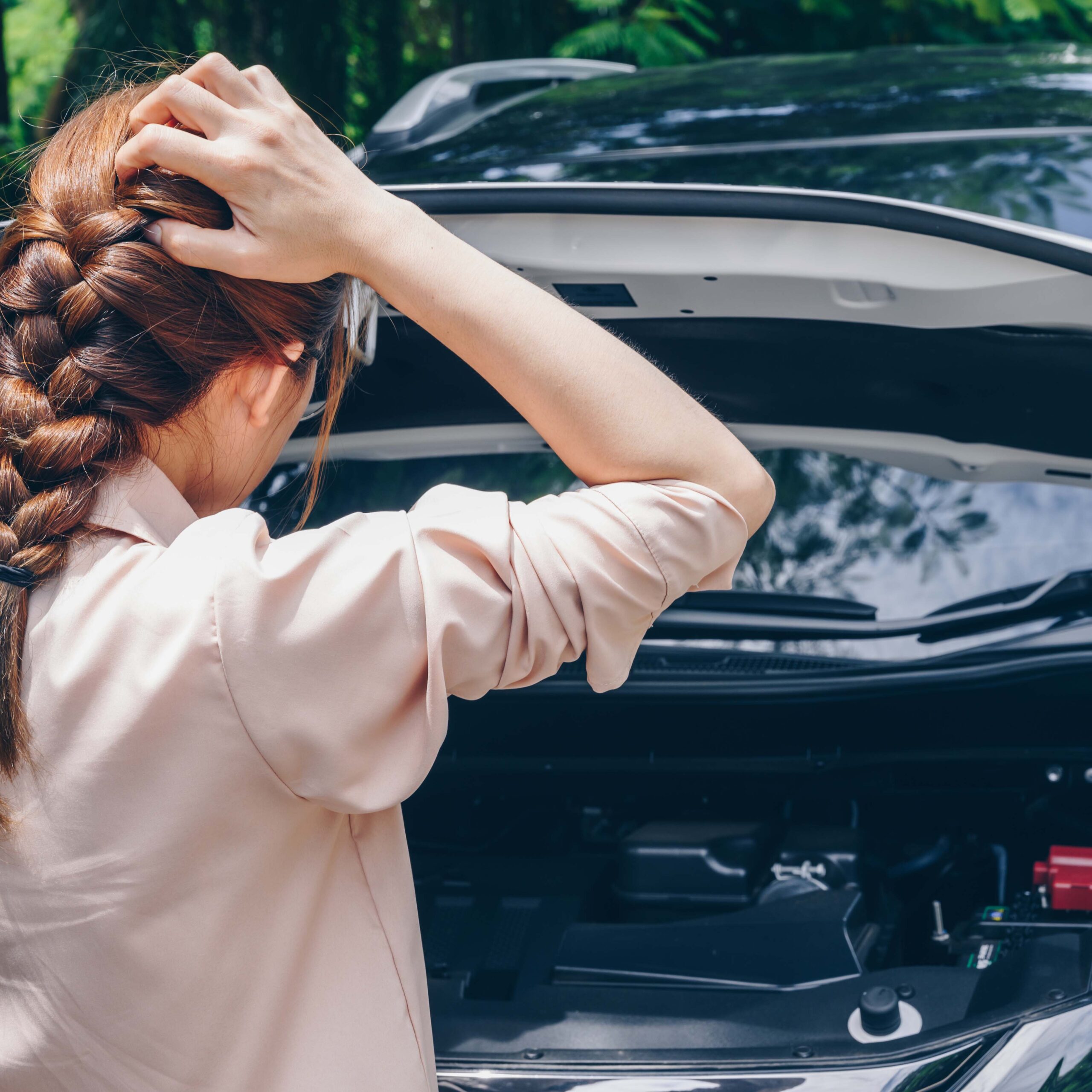 車のトラブルで困る女性